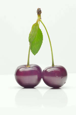 Cherries with leaves on white background, close-up
