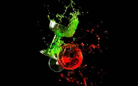 Clinking two glasses of red and green water splash on dark background.の写真素材
