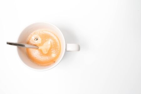 A hot fresh cup of coffee with a nice layer of coffee cream with a white background. home made coffee.の写真素材