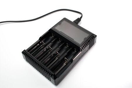 A black smart battery charger with a white background for charging of AA and AAA batteries.の写真素材