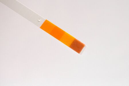 Closeup of a used pH paper test strip. Visual color laboratory test for testing of liquids.の写真素材