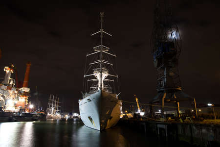 Front view of a big sail cruise ship, the Wind Surf, laying in the harbor at night awaiting...