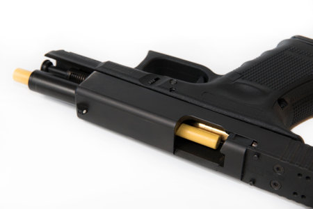 Closeup of a loaded pistol with a safety rod inside preventing shooting. Gun safety accessories...
