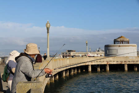 San Francisco, California, United States - NOV 12, 2014: a man is fishing at the old San Francisco pier.のeditorial素材