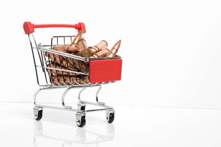Isolated small shopping cart with rifle ammunition inside. 7.62x39 rifle bullets. arms dealer.