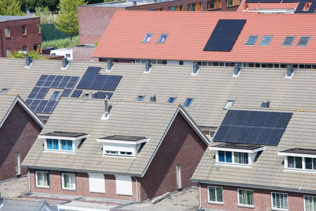 Houses with solar panels on the roofs from aerial view in The Netherlands. green energy.