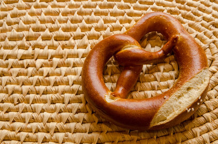 single pretzel on a woven serving tray