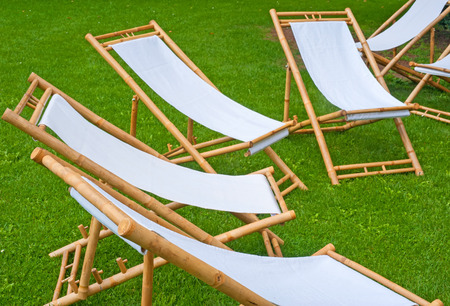 many folding chairs in a green park