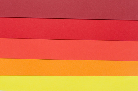 warm-colored construction paper sheets arranged horizontallyの写真素材
