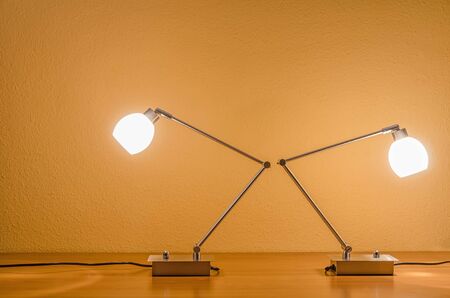 two lit table lamps turned away from each otherの写真素材