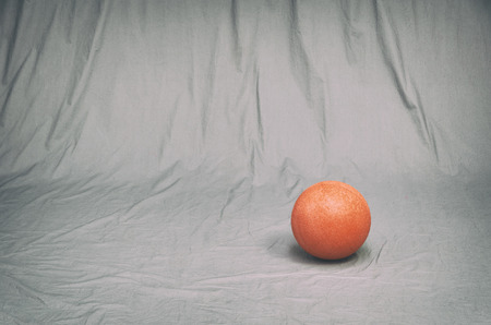 single red gaming ball on a grungy gray studio background. vintage filter effects.の写真素材