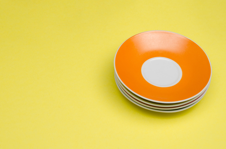 stacked colorful plates on yellow backgroundの写真素材