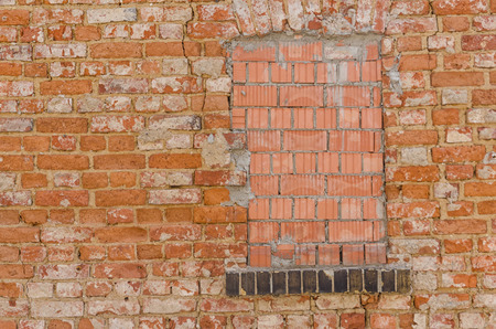 walled up window in an old grungy brick wall