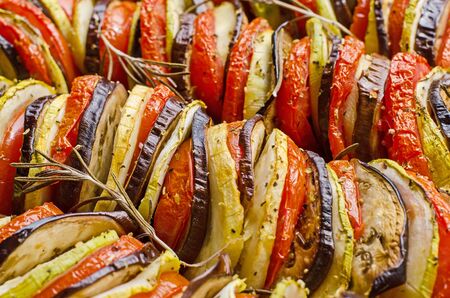 close-up of a vegetarian dish made of aubergine, tomatoes and zucchini in a mixture of satay and ratatouilleの写真素材