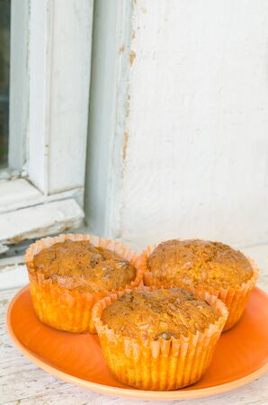 three lemon muffins cooling on an old white wooden window sillの写真素材