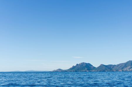 mysterious islands visible far away on the horizon in the sea on a clear sunny dayの写真素材