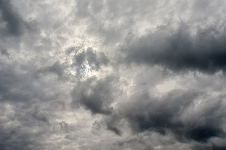 Stormy sky with clouds and sun behind them