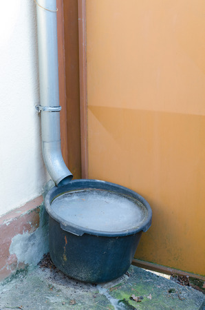 bucket collecting rain water near at a rural house completely frozen in winterの写真素材
