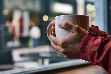 Holding a cup of coffee with blurry backgroundの写真素材