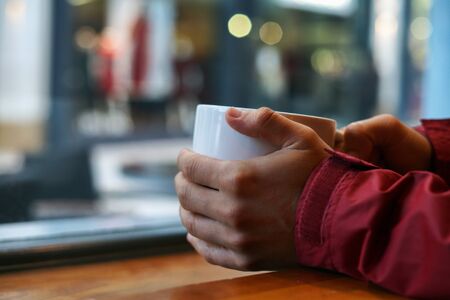 Holding a cup of coffee with blurry backgroundの写真素材
