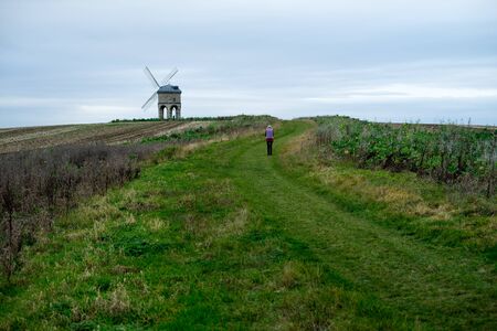 Old women is walking to see historical old Roman Empire architecture "Chesteron Windmill in UK"の写真素材