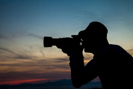 Photographer taking sunset photoの写真素材