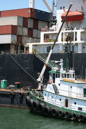 Tug Boat next to cargo ship