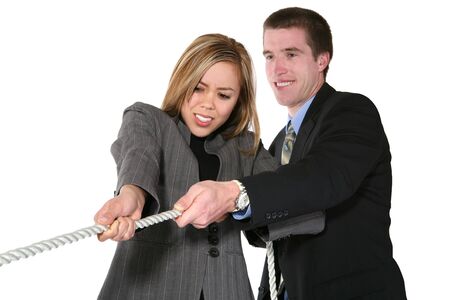 A business team playing tug of war in an intense stuggle (Focus on Woman)の写真素材