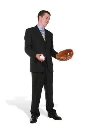 A business man with a baseball and glove yearning to play his sportの写真素材