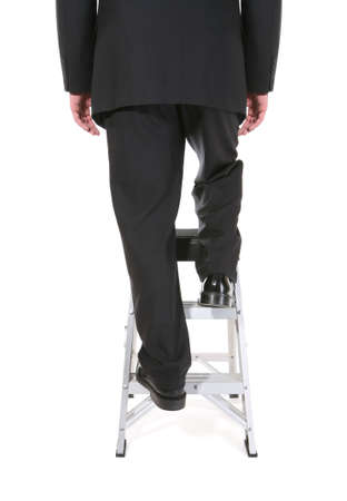 A business man climbing a ladder isolated over whiteの写真素材
