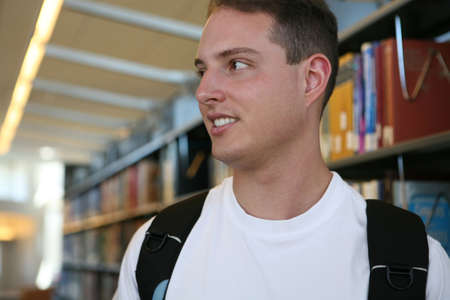 A young student in the library with a backpackの写真素材