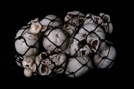 A scary bag of skulls over a black backgroundの写真素材