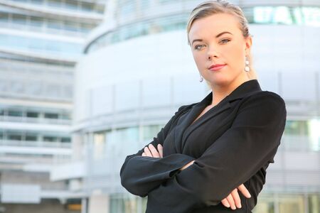 A beautiful blonde business woman in front of office buildingの写真素材