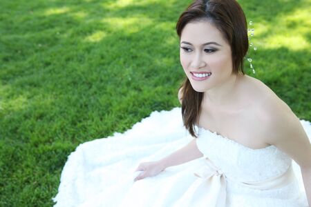 A beautiful young asian bride at wedding ceremony in the parkの写真素材