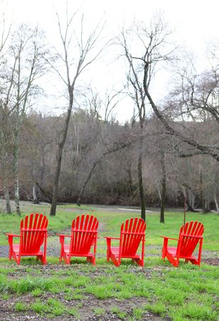 Four red chairs outdoors in the country landscapeの写真素材
