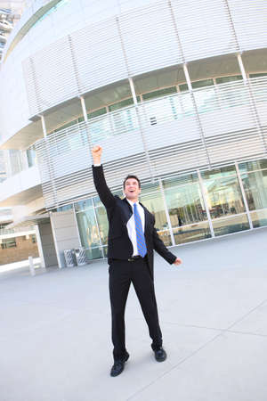 A young handsome business man at office building celebratingの写真素材