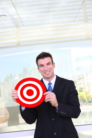 A handsome business man holding target at officeの写真素材