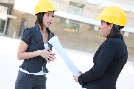 Two pretty diverse women architects on construction buidling siteの写真素材
