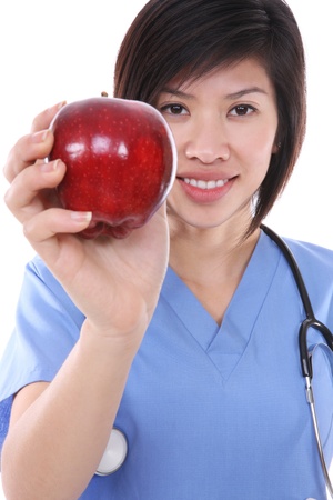 A pretty asian nurse holding a red appleの写真素材