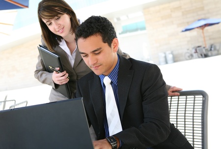 A pretty woman and man at office on computer talkingの写真素材