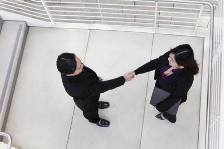 An asian business team shaking hands from aboveの写真素材