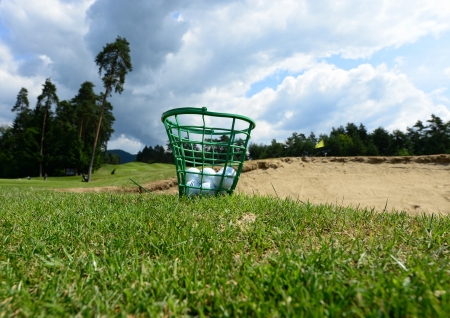 Golf balls in the basket on the grassの写真素材