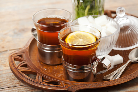 Set of cups with black tea on trayの写真素材