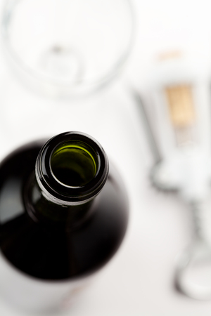 Close up of wine bottle with corkscrew and glass on the background on whiteの写真素材