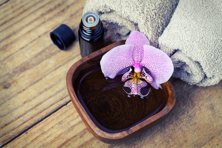 Spa setting with orchid, towels and essential oil on wooden の写真素材