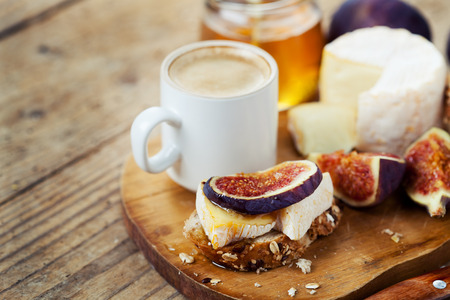 Breakfast setting with coffee, bread, cheese, figs and honeyの写真素材
