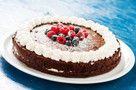 Homemade chocolate cake with cream and berries