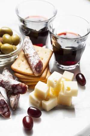 Red wine with charcuterie and grapes and olivesの写真素材