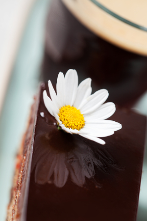 Chocolate cake with glass of coffee on a saucerの写真素材
