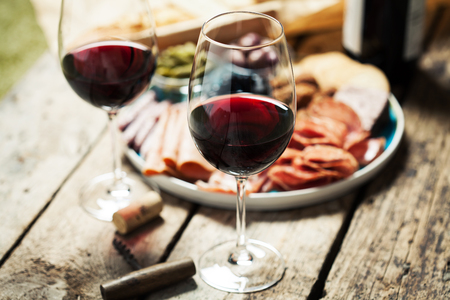 Red wine with charcuterie assortment on the background